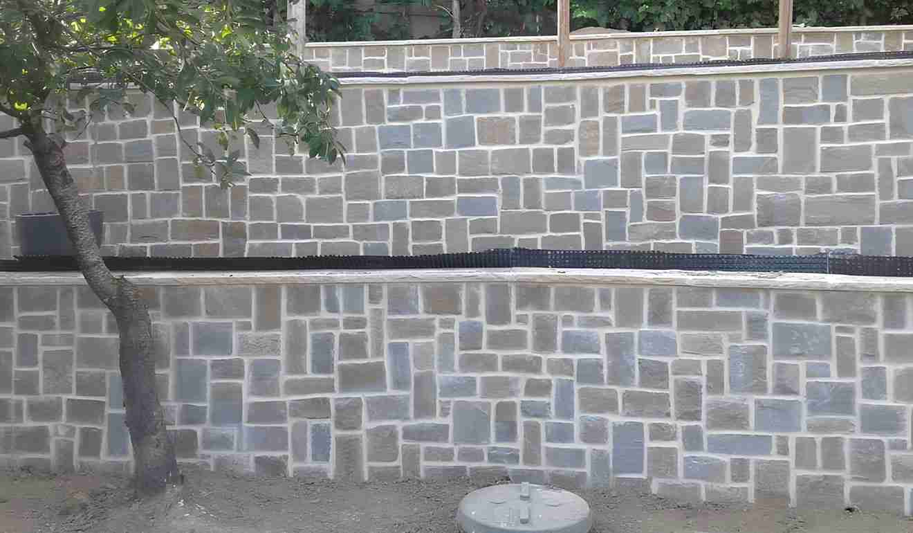 Muro di cinta di abitazione con pietre a vista.